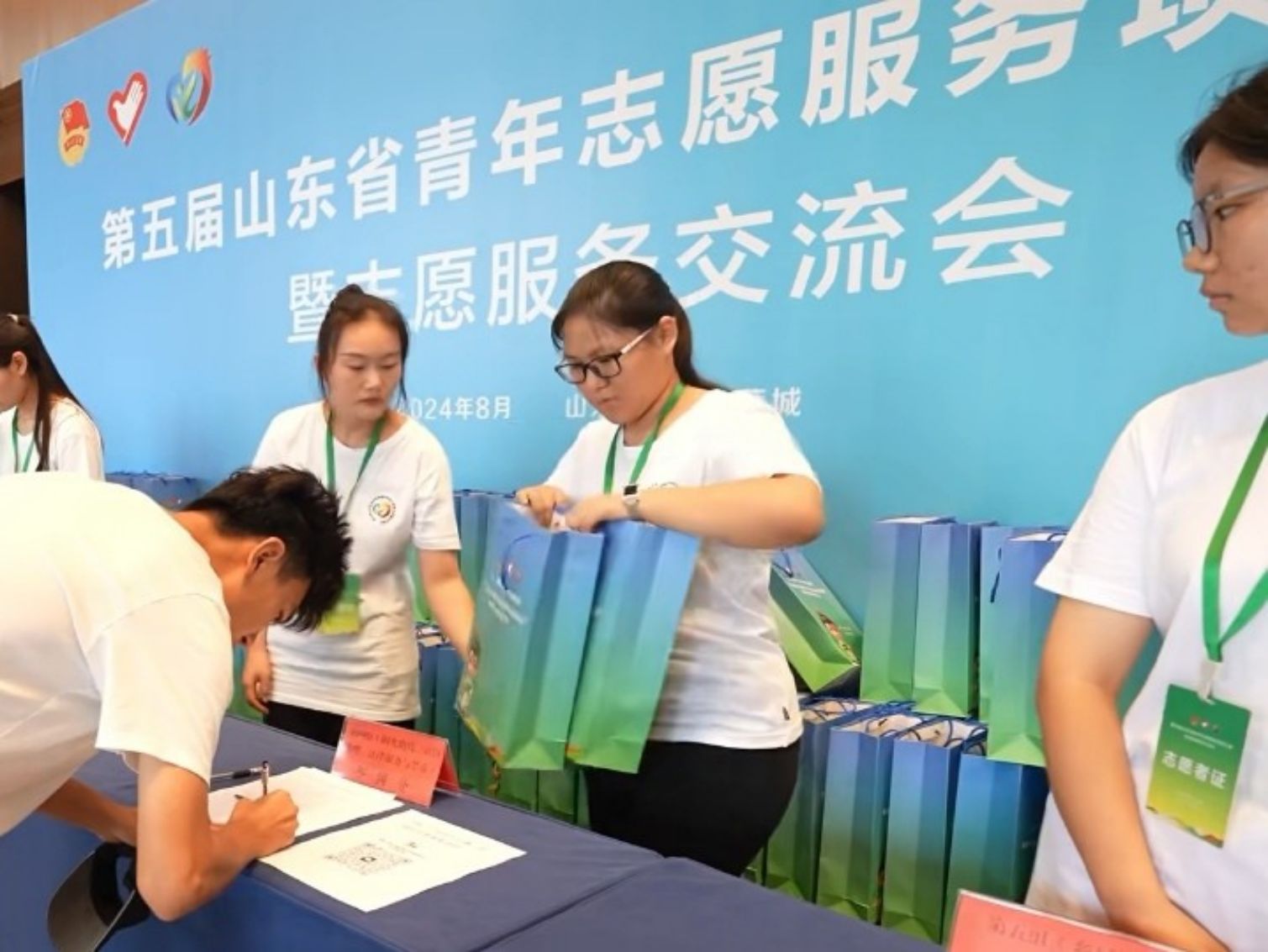圖為“新奇”實踐團成員給參賽者分發(fā)會務包